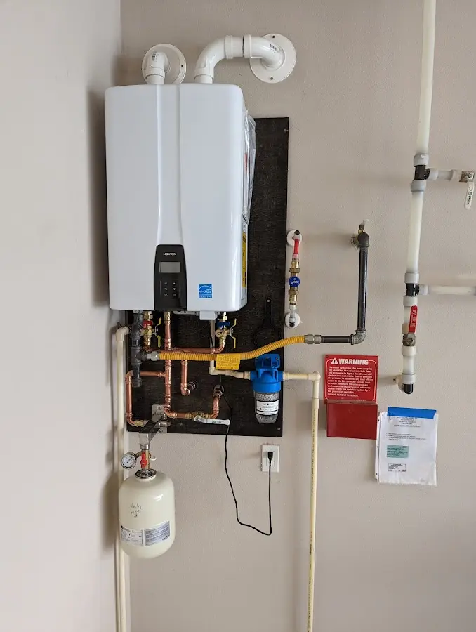 Professional plumber installing copper piping in a Colby home